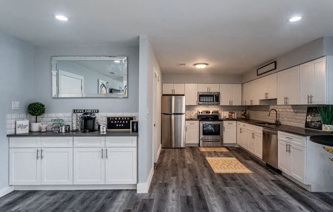 a kitchen with white cabinets and stainless steel appliances