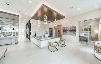 A modern kitchen with a marble backsplash and wooden chairs.