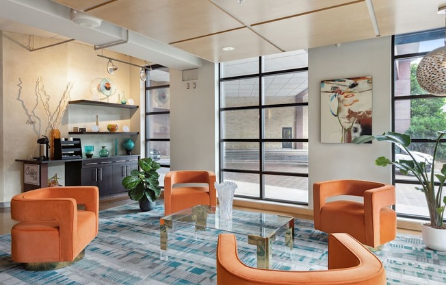 a living room with orange chairs and a glass coffee table