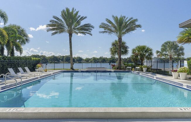 a large pool with palm trees and chairs around it at Lakeside Villas, Florida, 32817