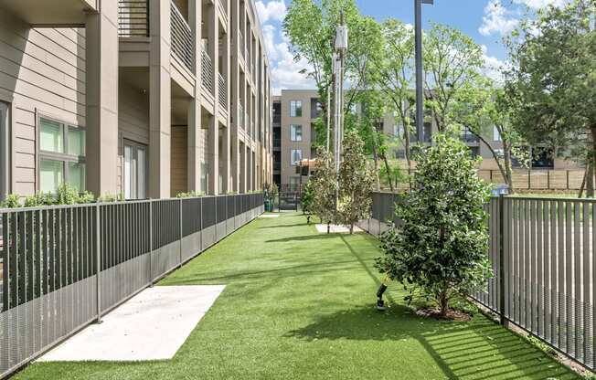 A grassy area in front of a building with a person walking.