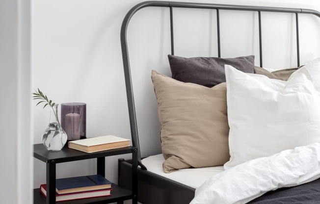bed with pillows with black side table with books