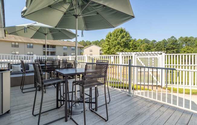 a patio with tables and chairs and umbrellas on a deck
