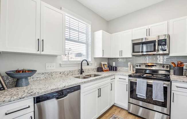 A kitchen with white cabinets and stainless steel appliances.