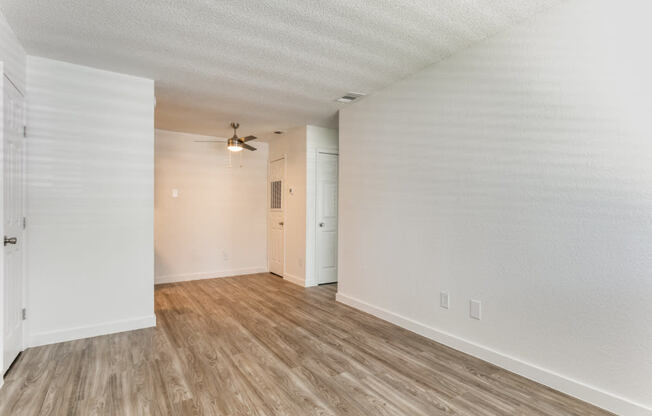 a bedroom with hardwood floors and white walls