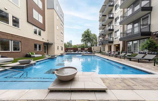 a swimming pool in front of an apartment building
