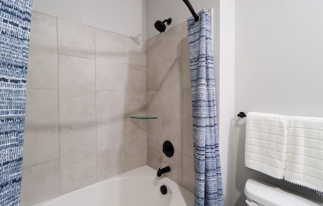 a bathroom with a shower and a toilet and a tub