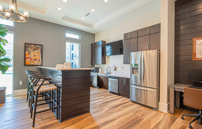 a kitchen with stainless steel appliances and a bar with stools