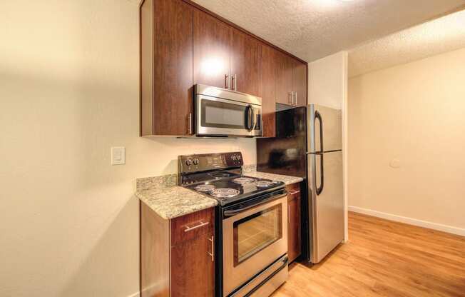 Kitchen with Wood Inspired Floors, Oven, Microwave and Refrigerator