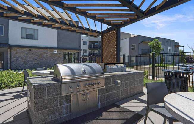 a patio with a grill and tables and chairs at The Flats at Riverwoods, Provo, Utah