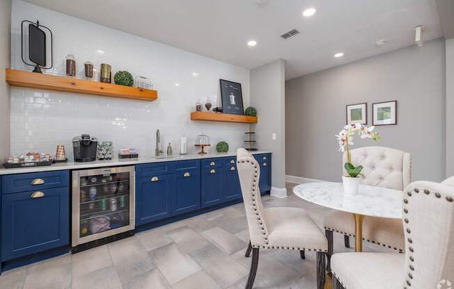 A kitchen with blue cabinets and a white table.