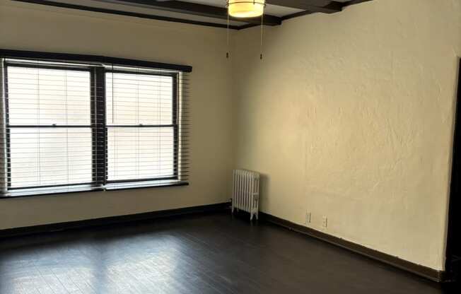 an empty living room with a ceiling fan and a window