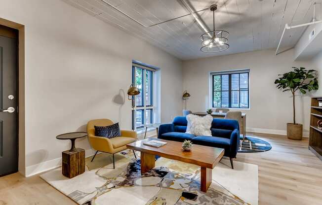 A living room with a blue couch and a yellow chair.