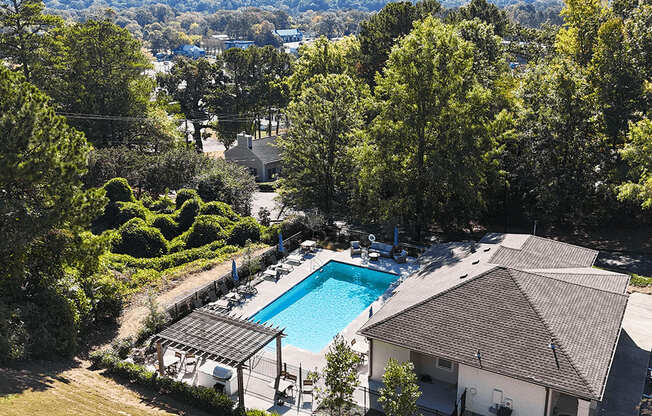 an aerial view of a swimming pool surrounded by buildings and trees