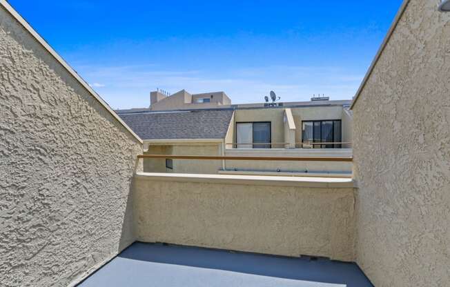 a balcony with a view of a building and a blue sky