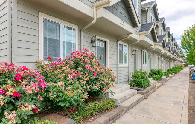 a row of houses with flowers in front of them