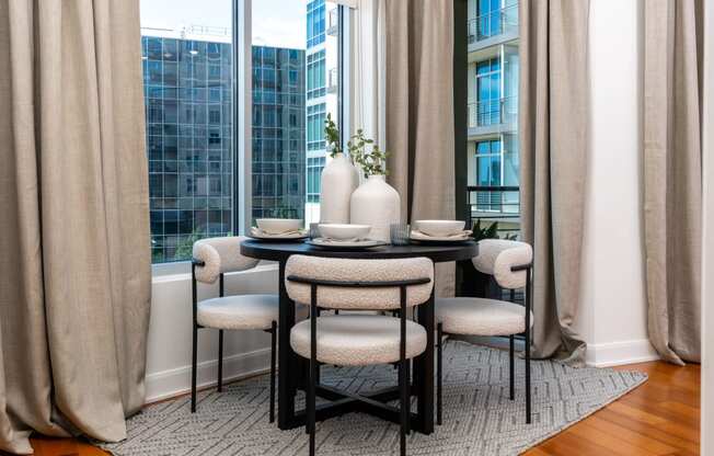 a dining room with a table and chairs in front of a window