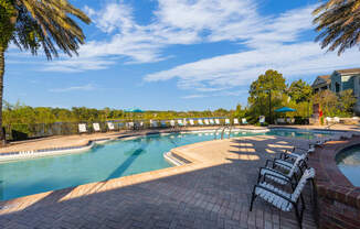 a resort style swimming pool with chairs around it