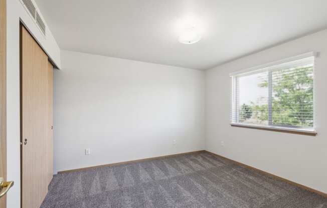 an empty room with carpet and a window