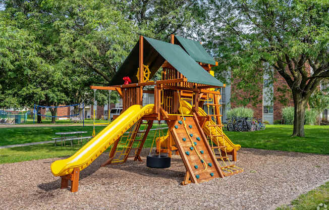 A wooden playground structure with a yellow slide.