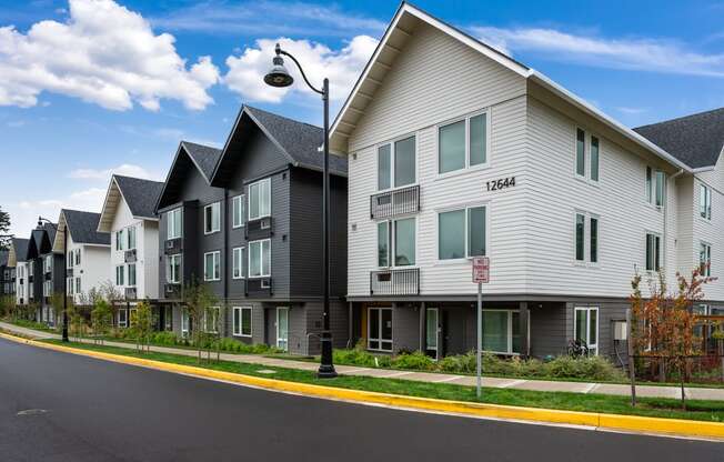a row of apartment buildings on the side of a street