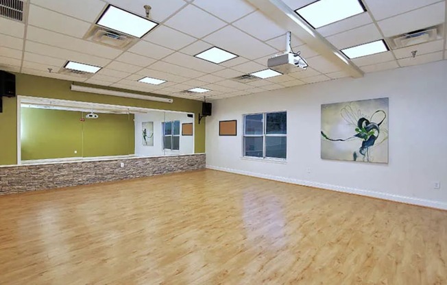 an empty room with a wood floor and white walls