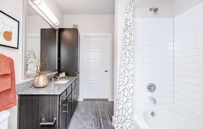 A bathroom with a black and white tiled shower.