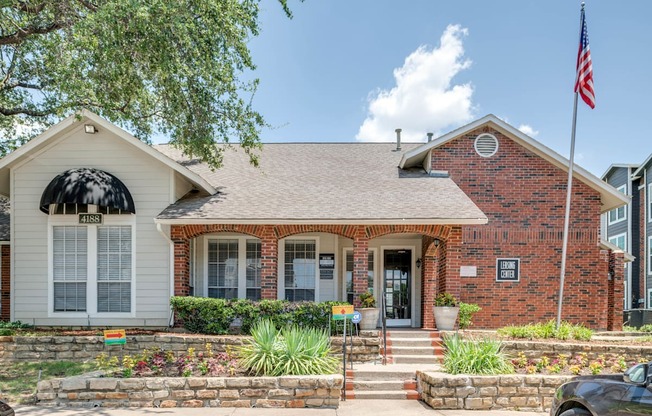 the front of a brick house with an flag on the side of it