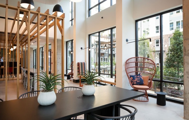 a dining room with a table and chairs and large windows