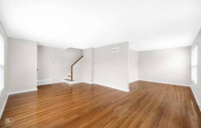 a bedroom with hardwood floors and grey walls