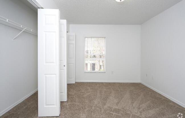 an empty living room with a window and a closet