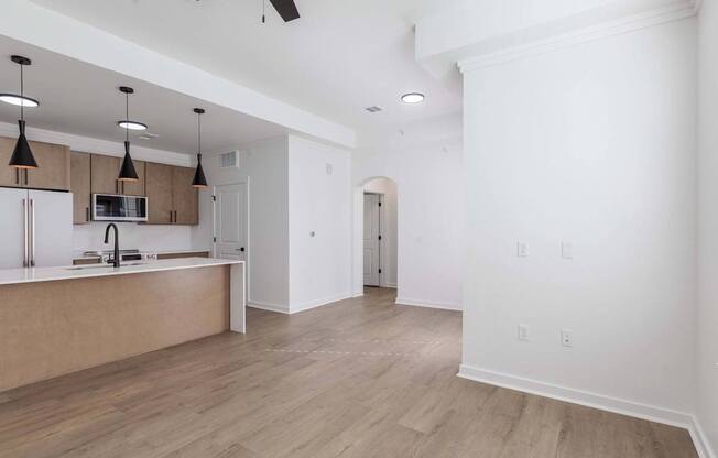 A kitchen with a refrigerator, microwave, and oven.