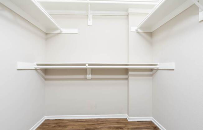 Empty room with white walls and wooden flooring.