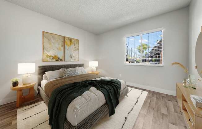 A bedroom with a large bed and a painting on the wall.