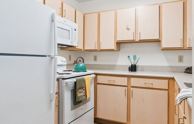 A kitchen with wooden cabinets and a white refrigerator.