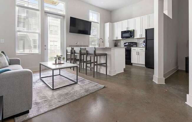 A modern living room with a grey couch and a white coffee table.