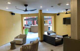 a lobby with chairs and a couch and a tv