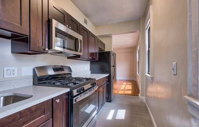 an empty kitchen with wood cabinets and stainless steel appliances