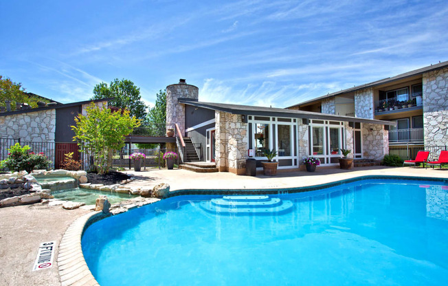 a swimming pool in front of a house with a pool