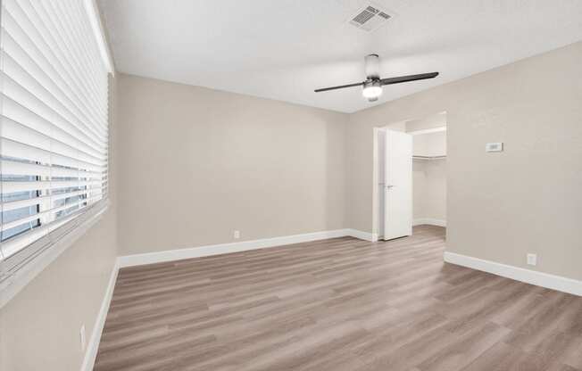 a bedroom with hardwood floors and a ceiling fan