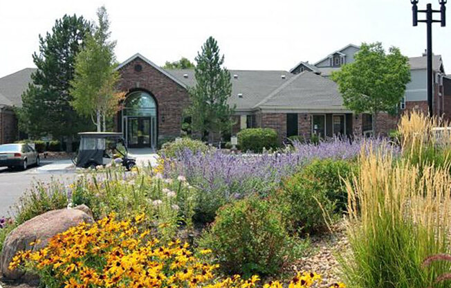 Westlake Greens Leasing Office brick front entrance with yellow flowers and plants in from