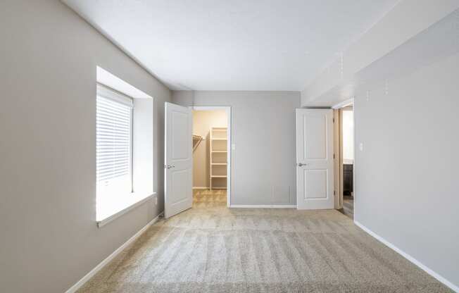 A Bright, Naturally Lit Master Bedroom in the One-Bedroom Apartment with Loft at Woodbridge Apartments Bloomington