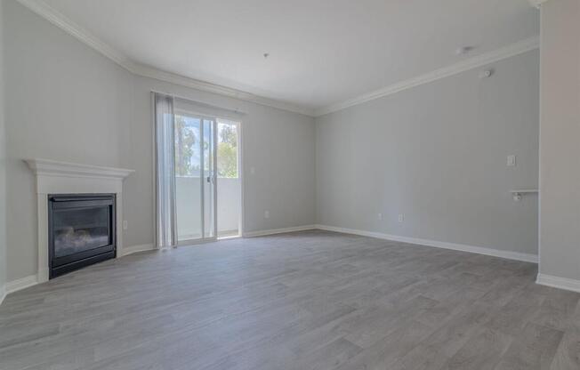 an empty living room with a fireplace and a sliding glass door at Warner Center Townhomes, Canoga Park, 91303