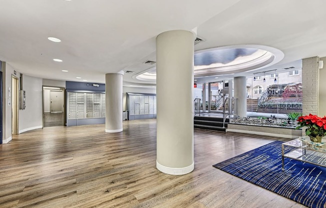 A large room with a wooden floor and a long white column.