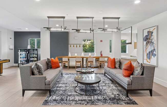 A modern living room with a grey sofa, a coffee table, and a dining table.