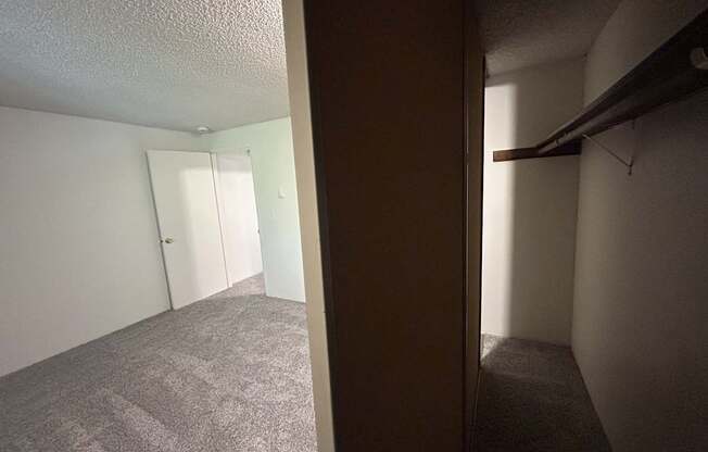 A room with a carpeted floor and a door on the left side.