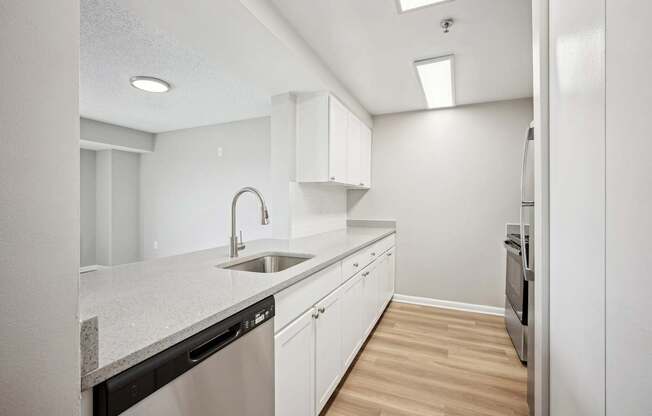 A modern kitchen with white cabinets and a granite countertop.