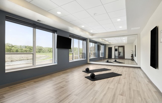 a spacious yoga studio with large windows and a large screen tv