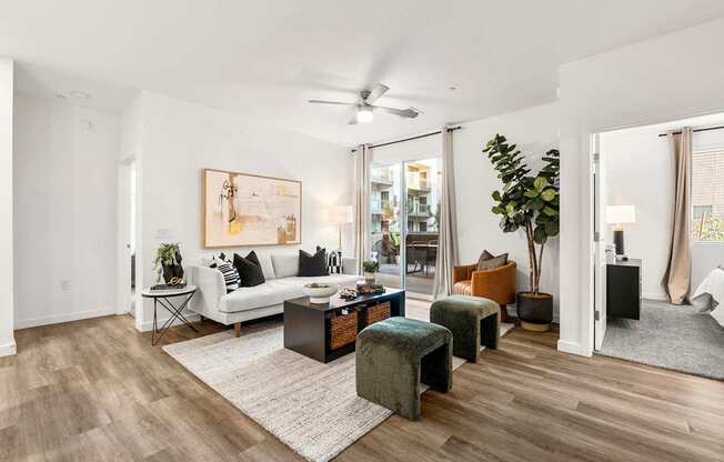 A living room with a white couch, a coffee table, and a painting on the wall.