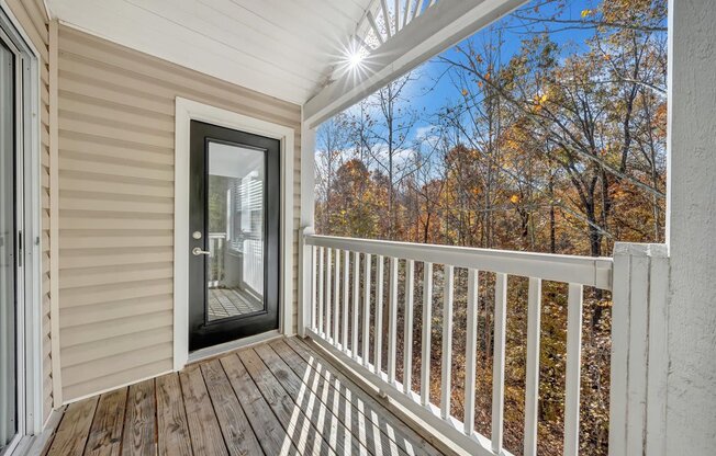 the deck of a home with a glass door to a porch